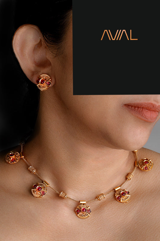 Woman wearing traditional South Indian temple necklace set with antique gold finish and red stones – perfect for UK cultural and festive events
