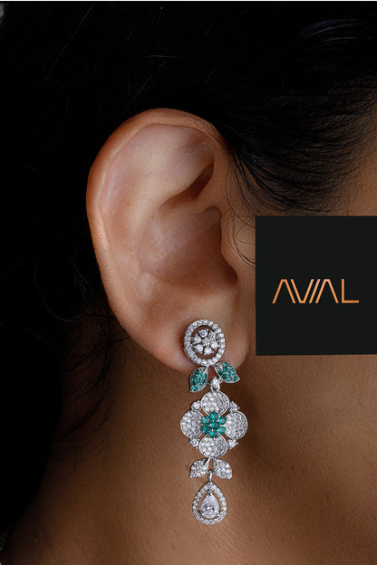 Close-up of green and white floral earrings with sparkling American diamonds and emerald accents – perfect for UK wedding and party looks