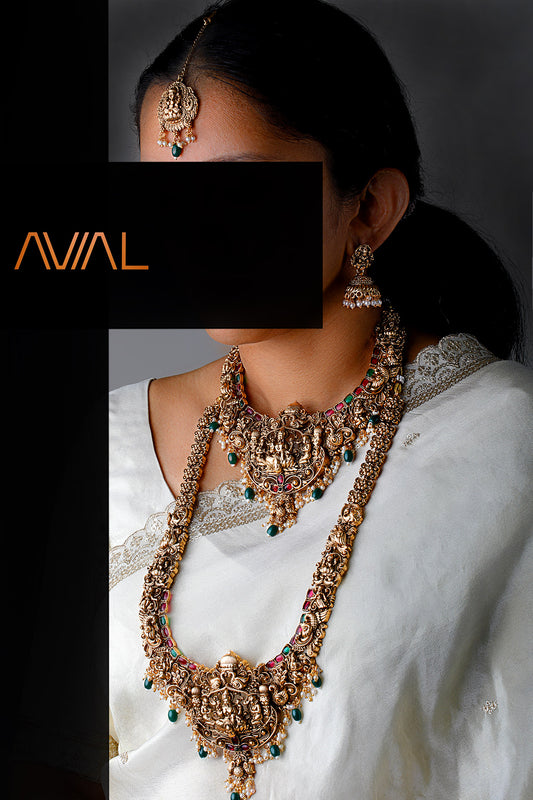 Complete South Indian bridal temple jewelry set in antique gold featuring Lakshmi choker, long haar, earrings, and maang tikka
