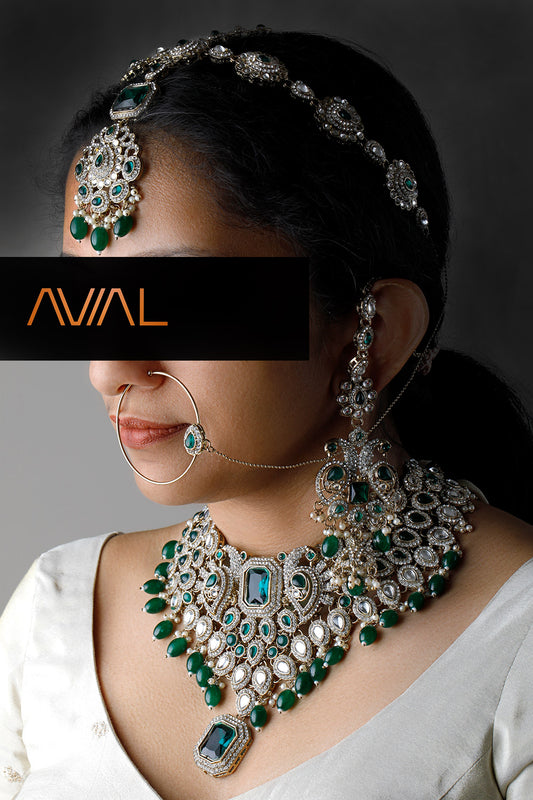 Indian bridal jewelry set with emerald stones and silver plating – necklace, maang tikka, earrings and nath set