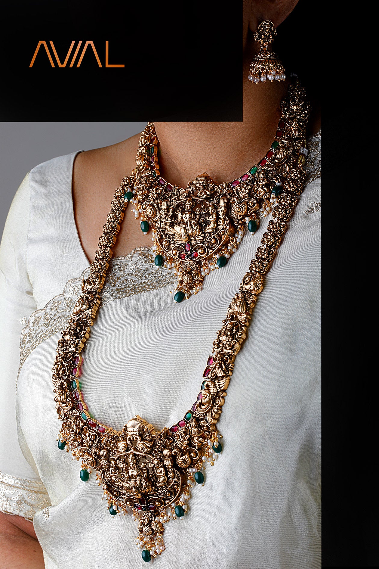 Indian bride wearing full temple jewelry set including choker, long haar, earrings, and maang tikka in antique gold